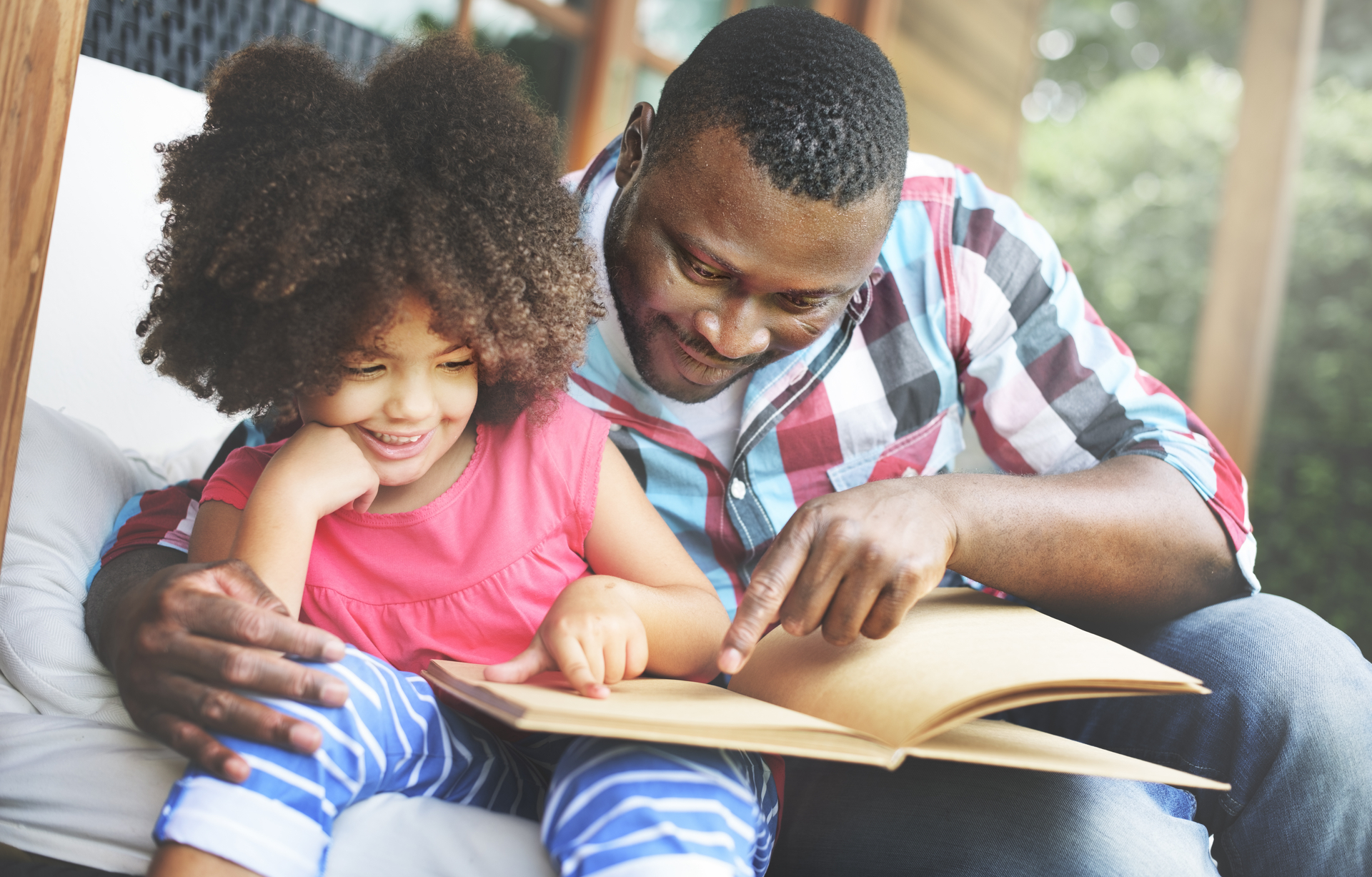 A father and his daughter reading together.