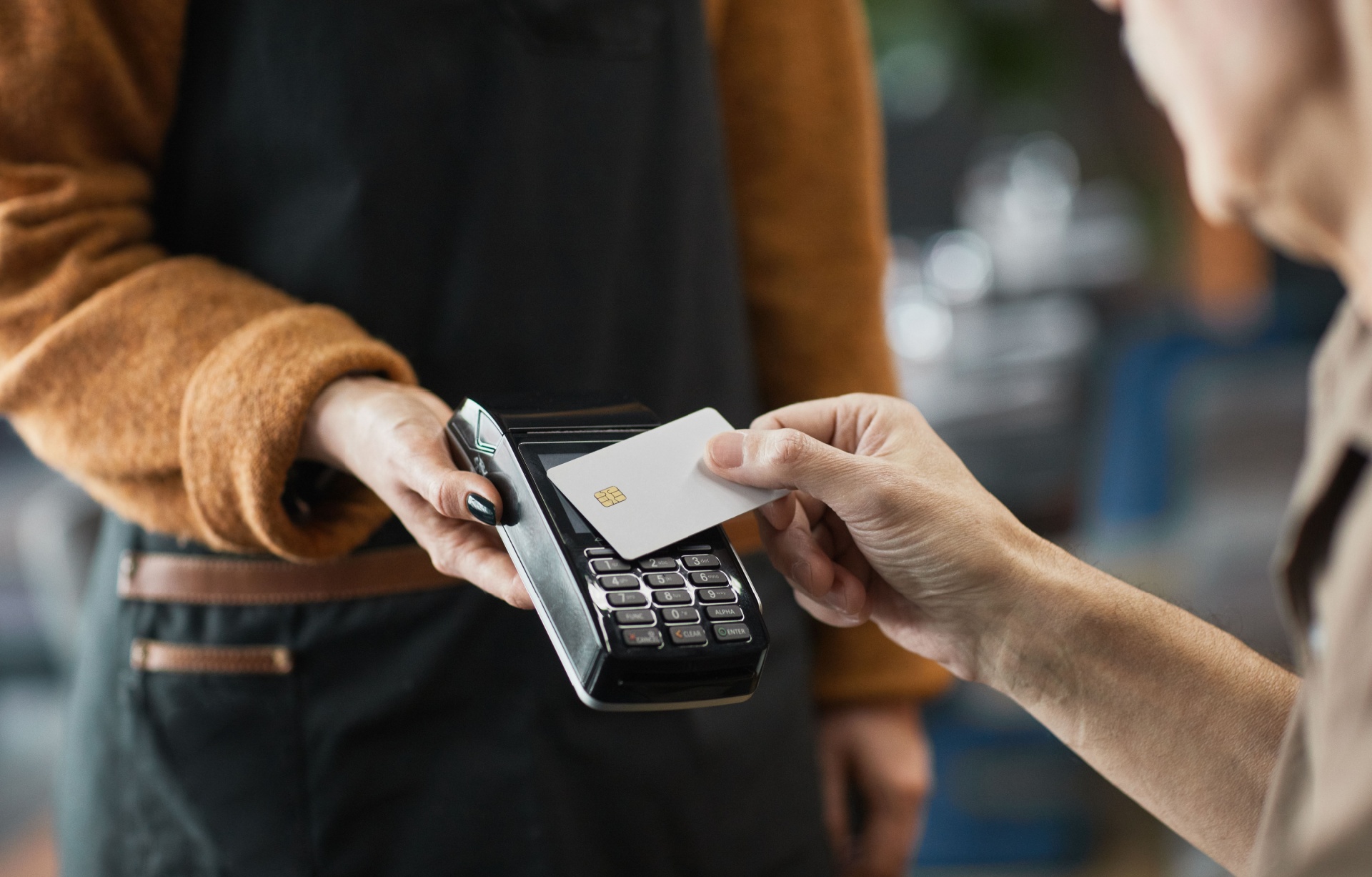 A person paying in a cafe using a contactless card.