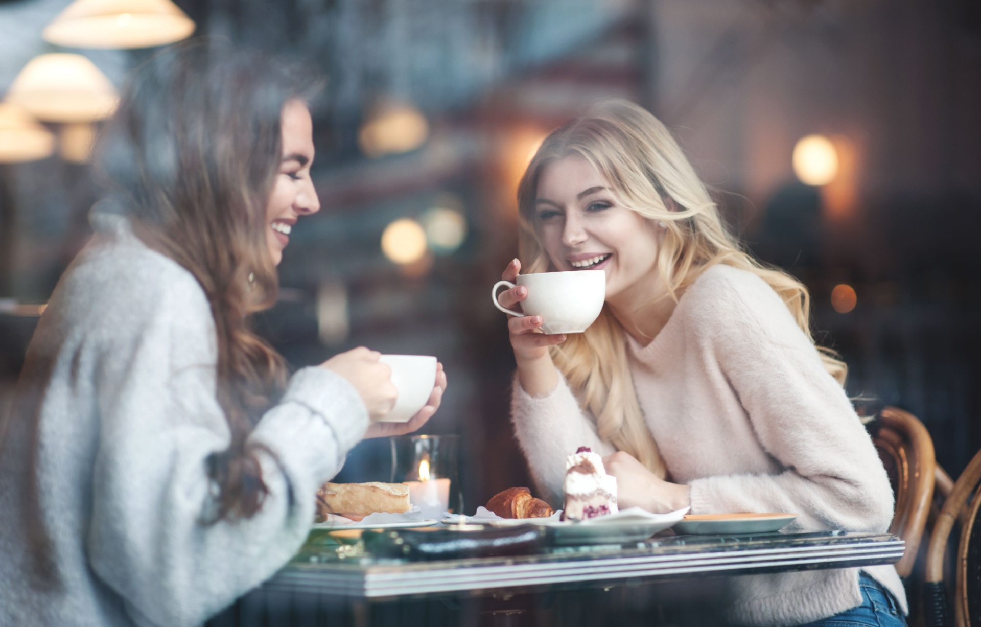 Two women talking and drinking coffee.