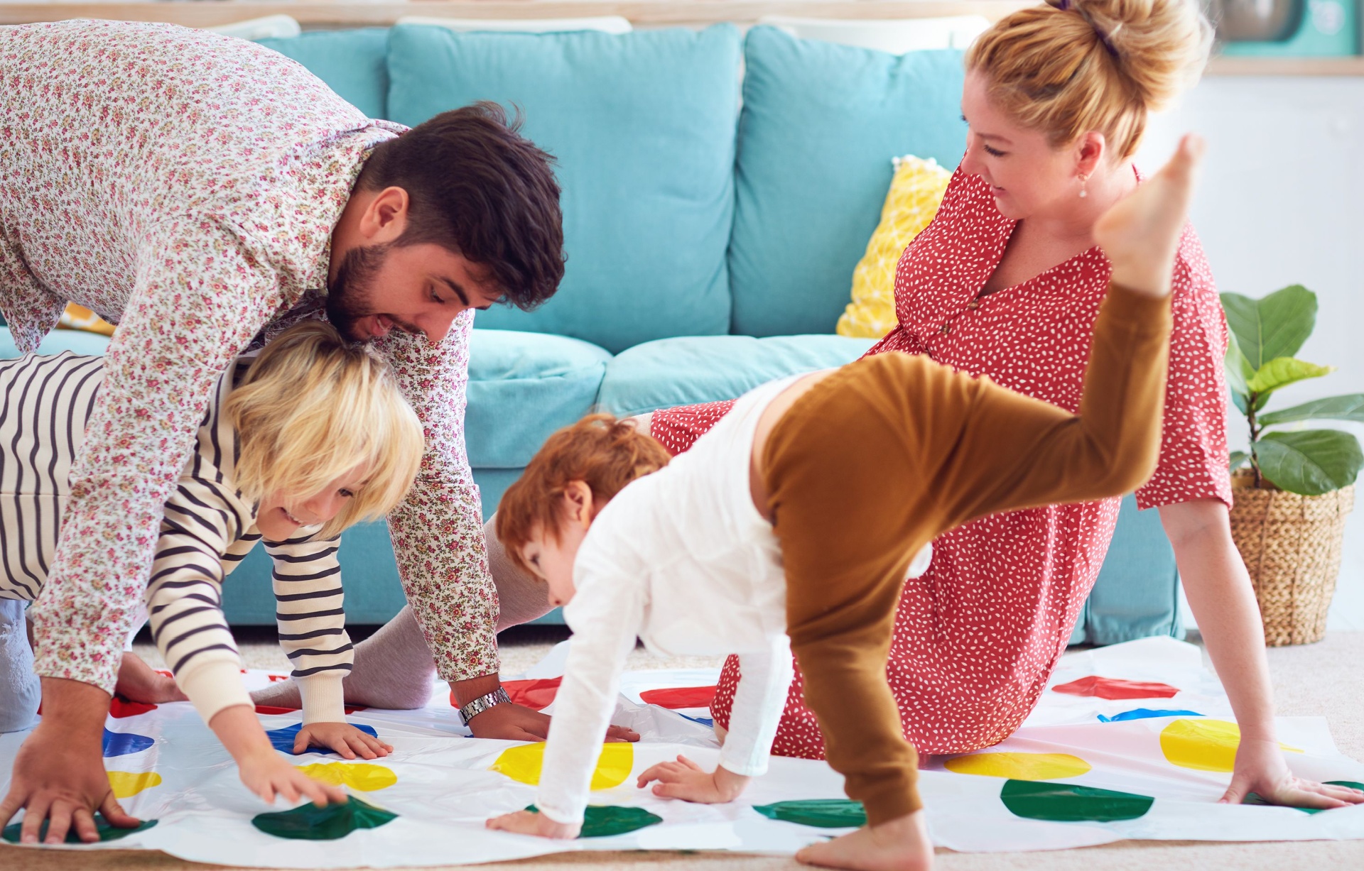 A family with young children playing Twister.