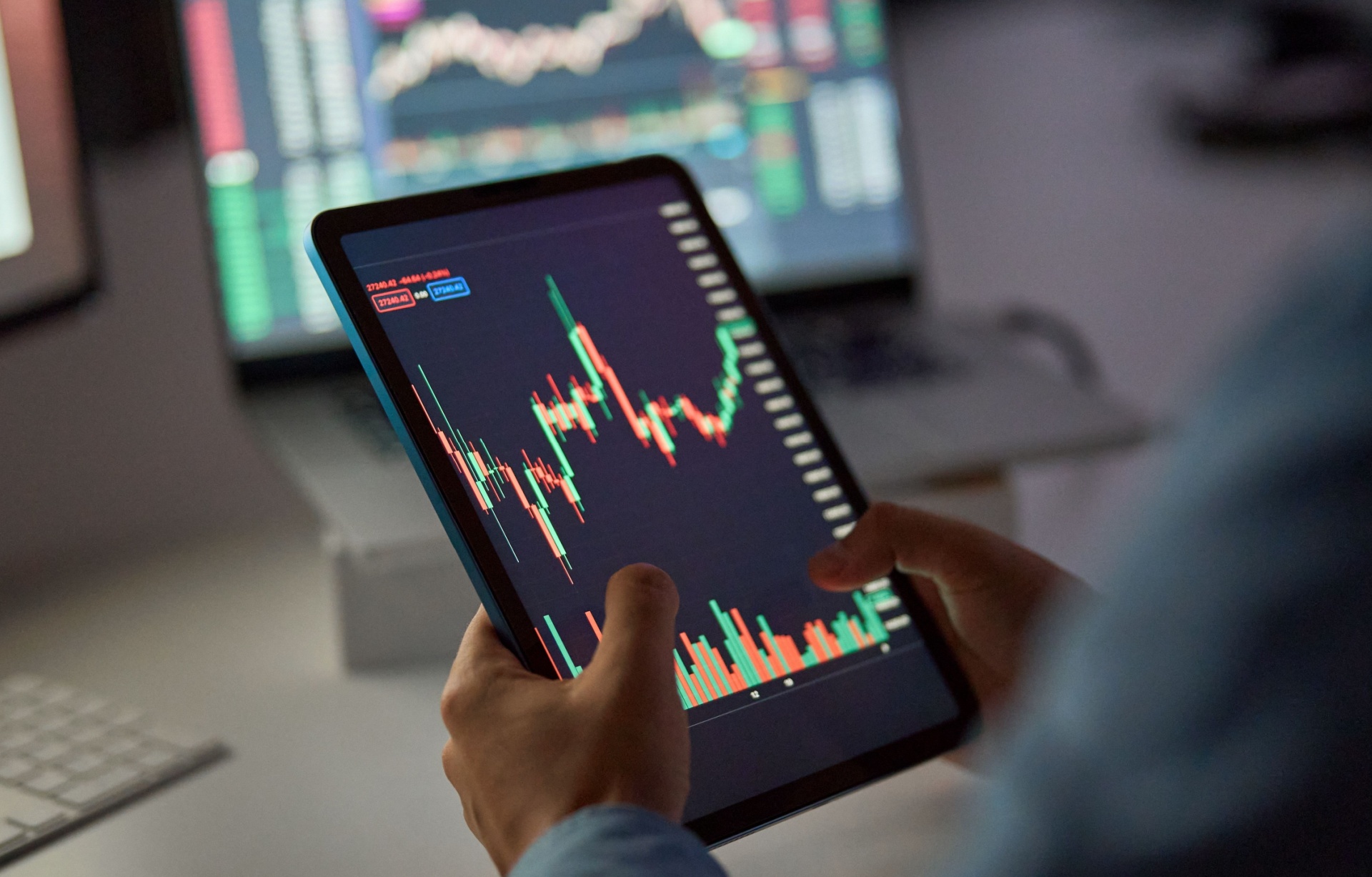 A person looking at a stock market graph on a tablet.