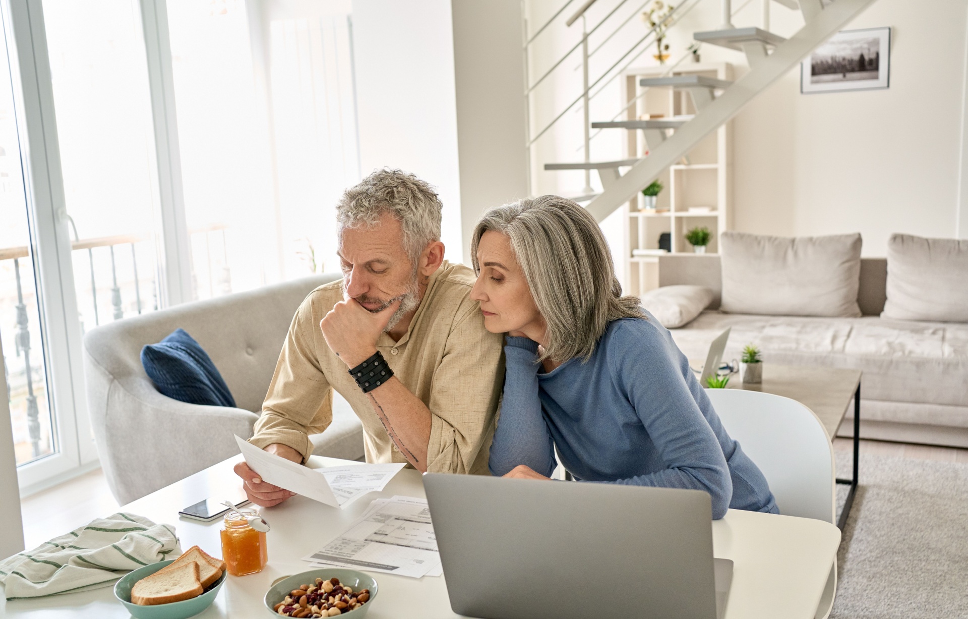 A couple looking at paperwork together in their home.