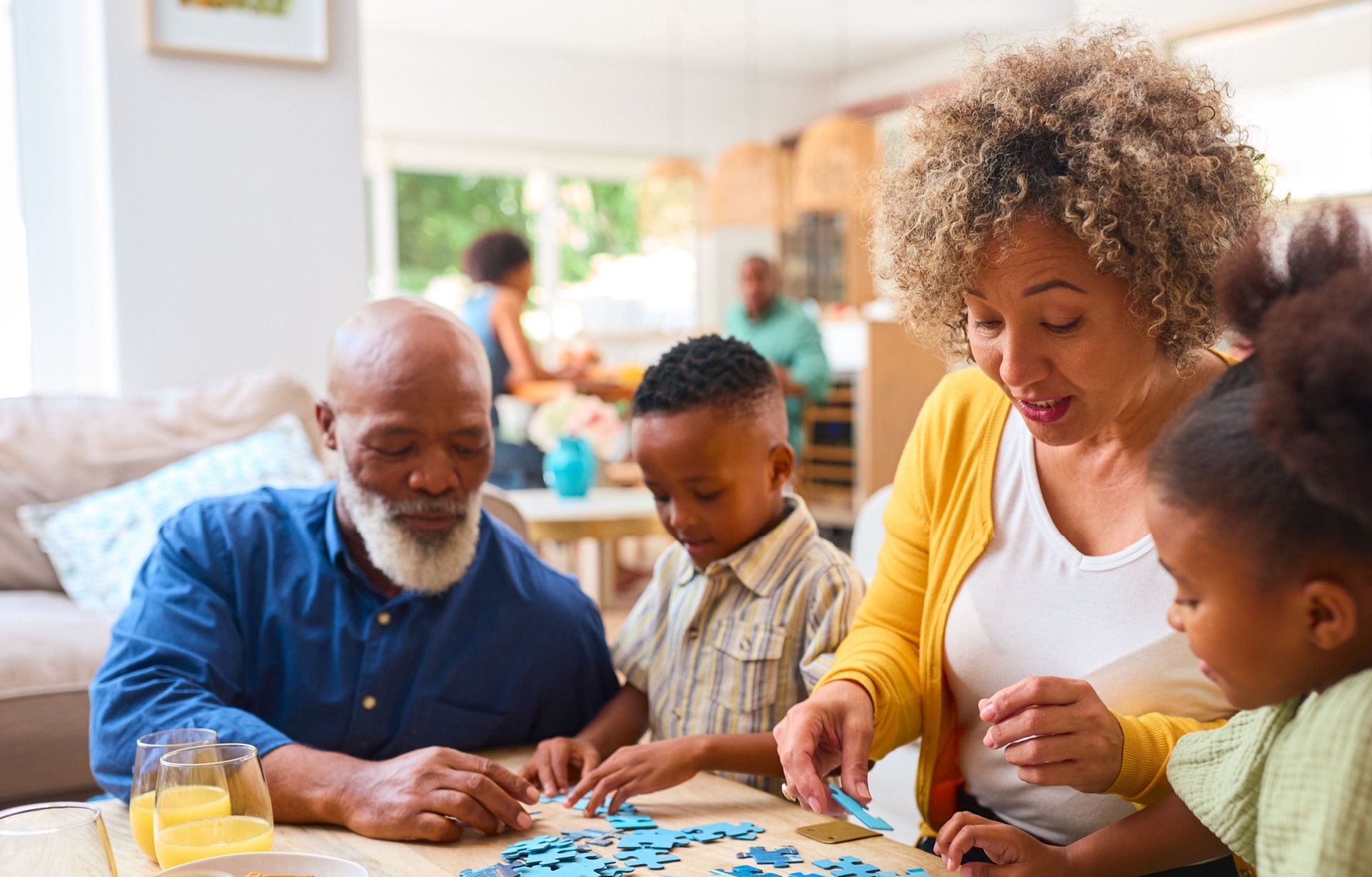 Grandparents doing a jigsaw with their two grandchildren.