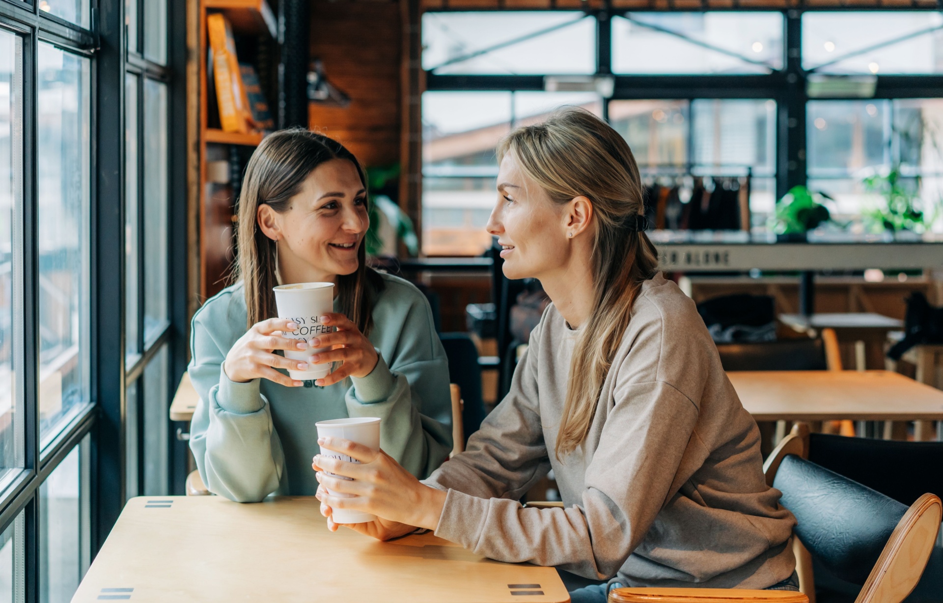 Two women talking in a coffee shop.